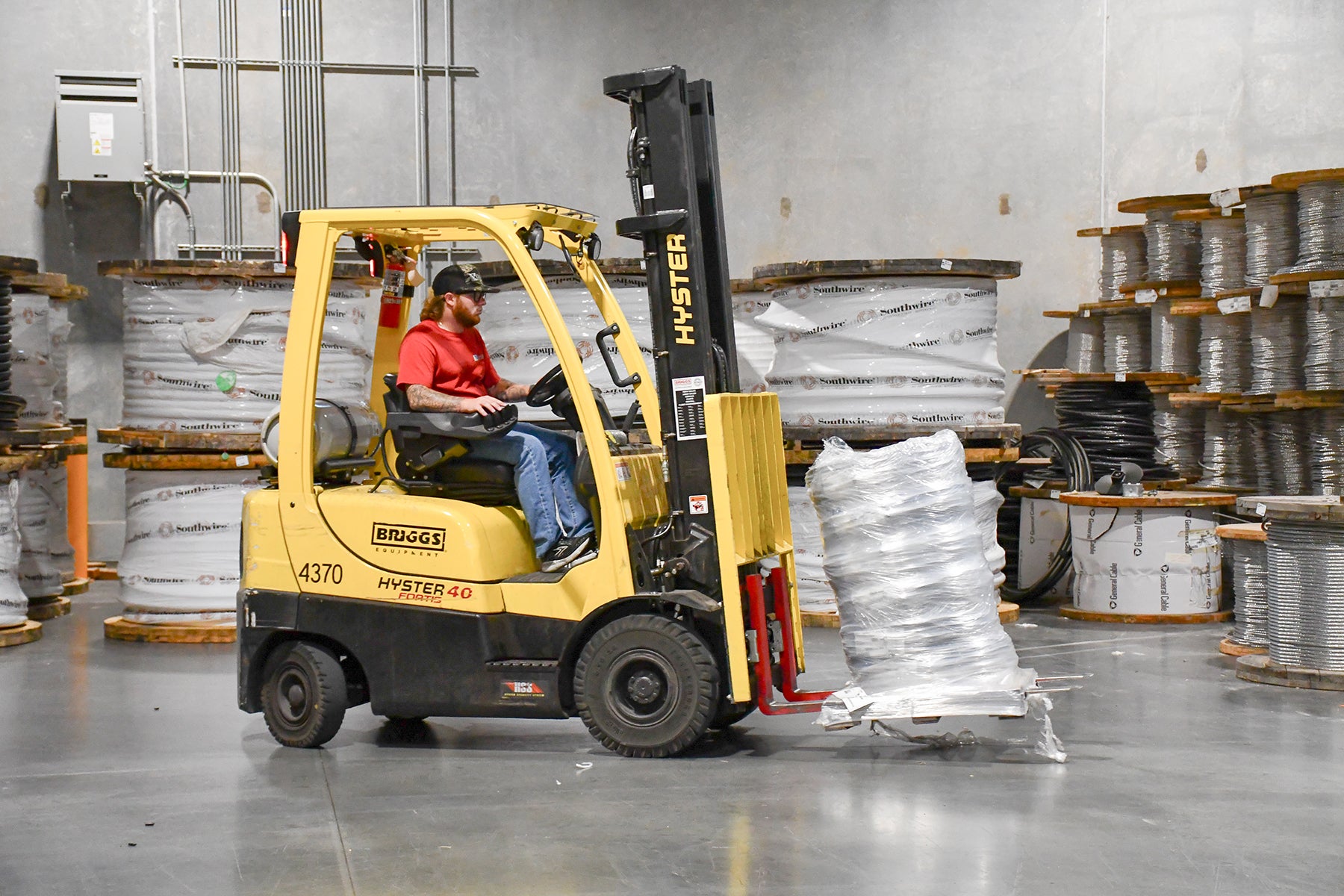 A warehouse employee uses a forklift. 